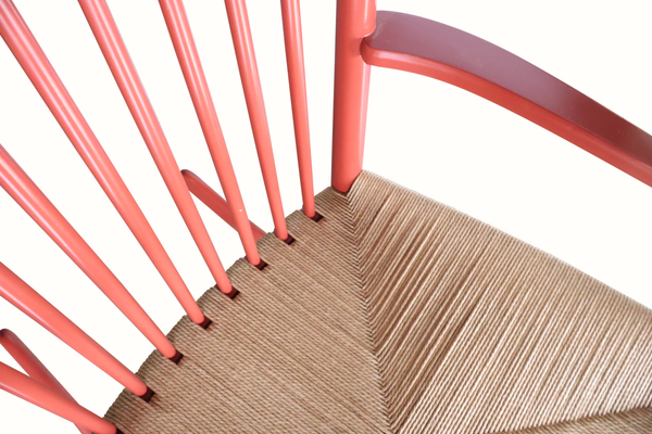Rocking chair seat and slatted back detail, woven beige cushion on red frame