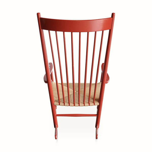 Red rocking chair front view with tall slatted back and woven beige seat