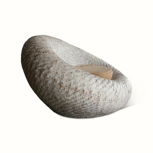 French rattan lounge chair side view with thick woven weave and beige cushion
