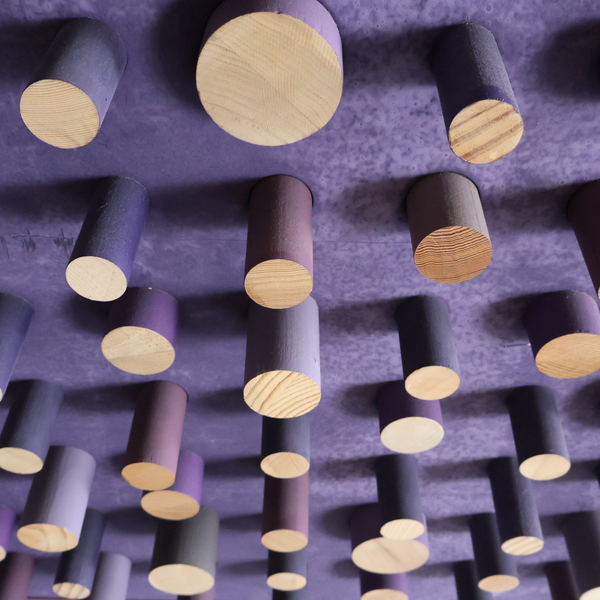 Close-up of purple peg art board with assorted light-wood circular pegs