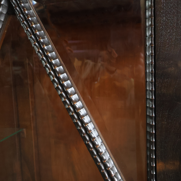 Closeup of faceted glass panel with silver metal lattice trim in a diamond shape