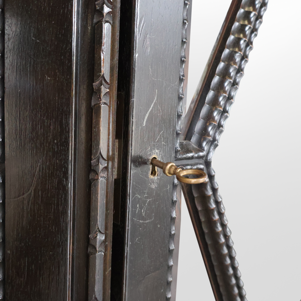 Bronze ring handle and metal hinge detail on faceted glass cabinet door
