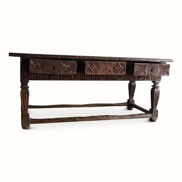 Carved oak table side view with geometric carvings on apron and turned legs