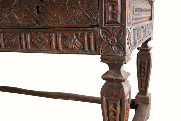 Carved oak table corner with ornate carvings and turned leg detail