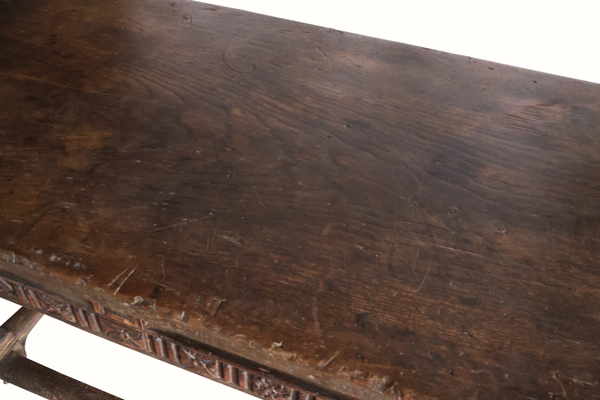 Carved oak table top with scuffs and scratches, dark brown finish