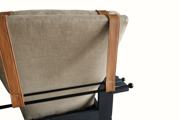 Reclining armchair close-up: beige fabric, tan leather trim, dark arm frame
