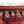 Turkish kilim rug edge, black ground with orange trim, repeating geometric figures and fringe.
