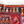 Turkish kilim rug corner, black band with orange and yellow motifs, white fringe tassels.