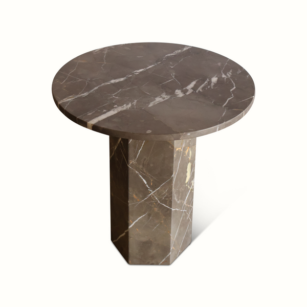 Round dark marble side table with white veining and tapered stone base
