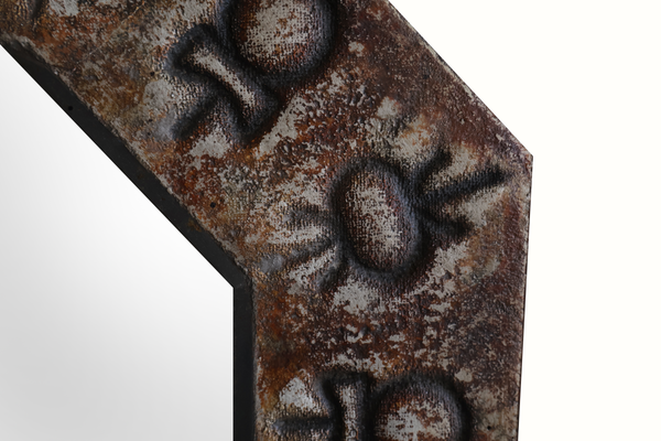Close-up of octagonal ceramic mirror frame with bronze-toned floral relief
