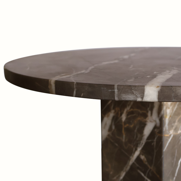 Close-up of round dark marble tabletop edge with white veining on column base