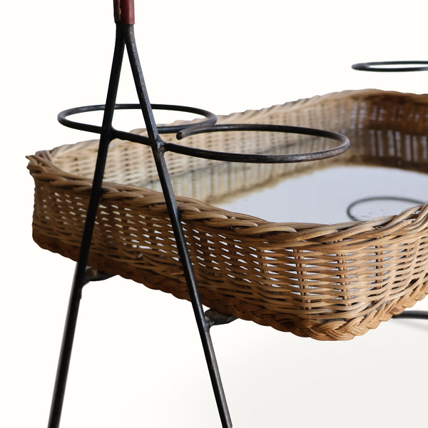 Wicker mirrored top tray table with woven base and black iron supports, dark red handle post