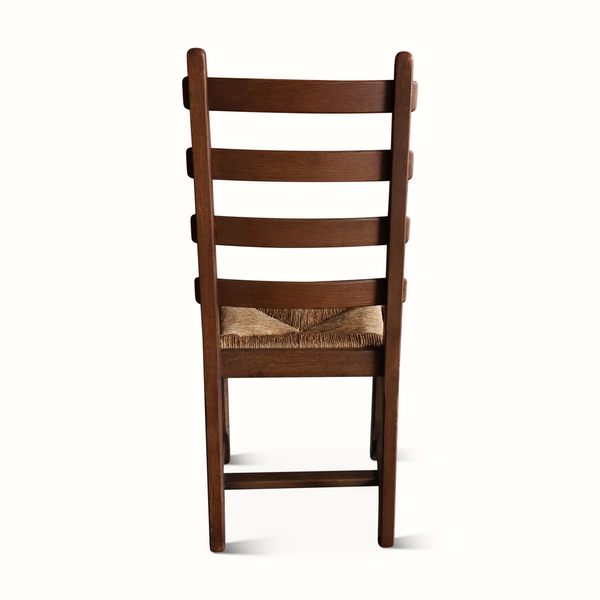 Oak ladderback chair back view with woven beige seat cushion and dark wood slats.