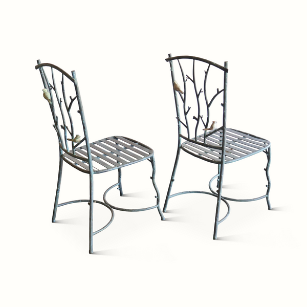 Two metal side chairs with blue-gray faux-bois frames, branch backs, and slatted seats