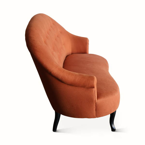Orange-brown velvet accent chair sofa with deep seat, tufted back, dark legs