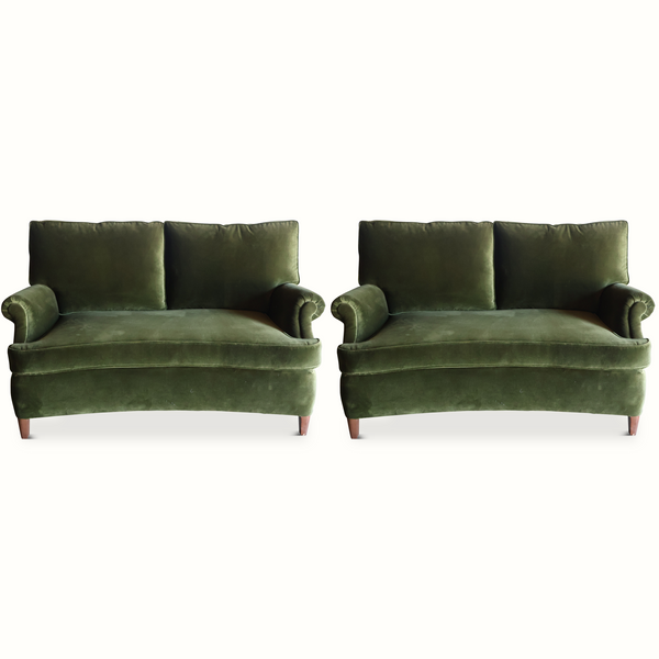 Green velvet French-style sofa with two seat cushions and tufted backrest, rolled arms