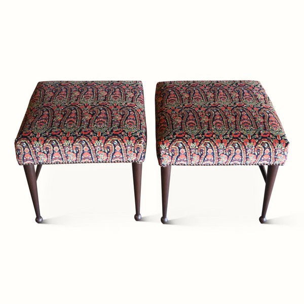 Two upholstered stools with patterned fabric seats and dark wood legs