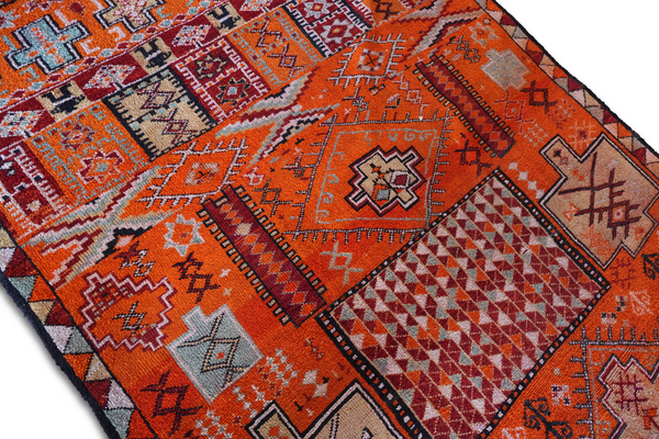 Orange rug with diamond and zigzag patterns, multicolor medallion, fringed border