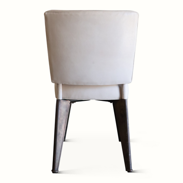 Back view of light upholstered leather accent chair with dark tapered legs