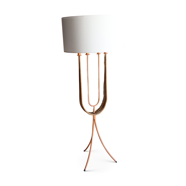White fabric shade floor lamp with curved rattan-like base and three slim metal legs