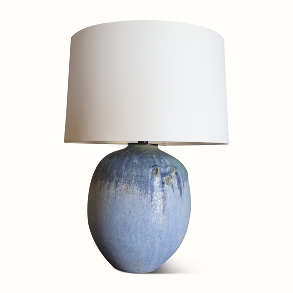 Blue glazed ceramic lamp with off-white drum shade and textured spherical body