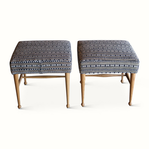 Two upholstered stools shown from front, dark patterned fabric with blue geometric bands