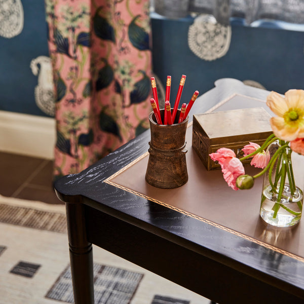 Dark wood desk with drawer; styled writing surface
