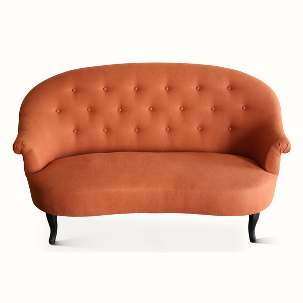 Orange-brown velvet sofa with button-tufted back, wide seat, and dark legs