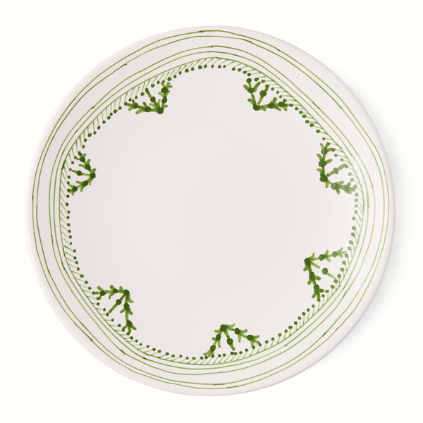 Dinner plate with white center and green painted border with dots and vines