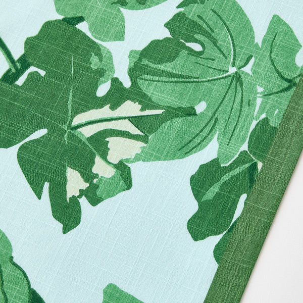 Close-up of green leaf print on pale blue runner fabric
