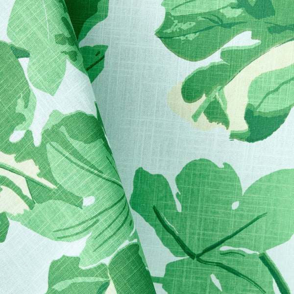 Close-up of leaf-printed tablecloth fabric with pale blue and green pattern