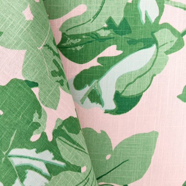 Close-up pink tablecloth fabric with green fig leaf pattern