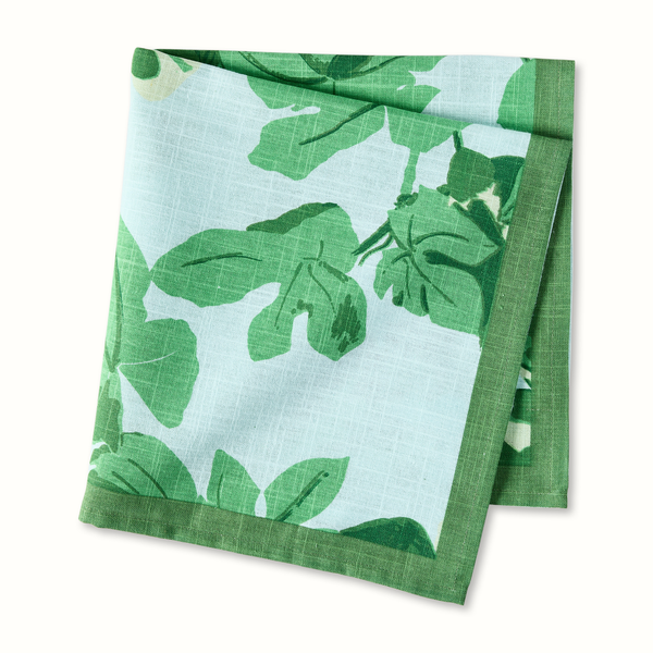 Green and pale blue printed napkin, folded square with leaf-and-fig pattern