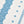 White runner rug with scattered blue medallion motifs and blue tassel trim along edge