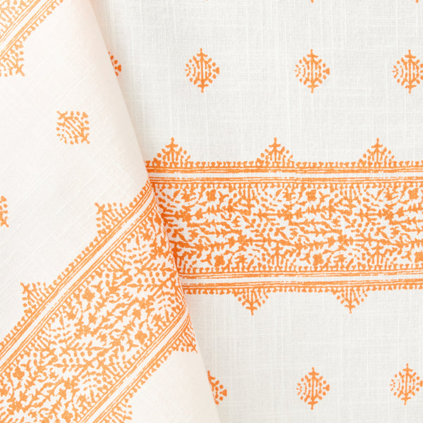White tablecloth with orange geometric motifs and patterned border