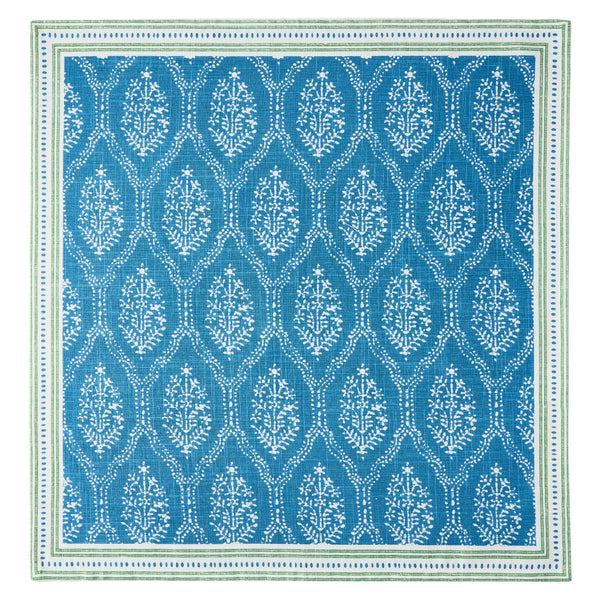 Blue printed fabric napkin with white leaf-like pattern and green-trimmed border, flat square.