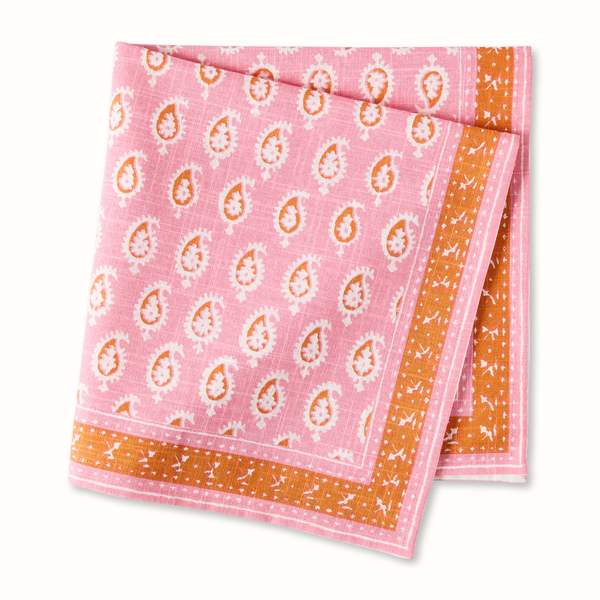 Pink paisley printed napkin with orange border, folded