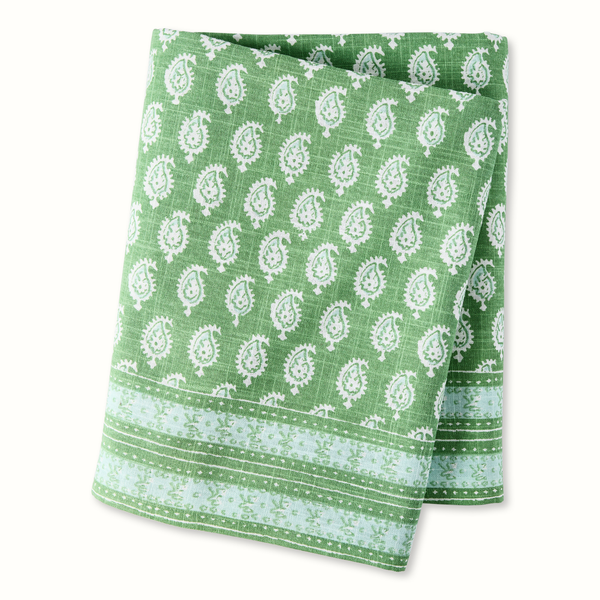 Green printed tablecloth with white paisley medallions and striped border.