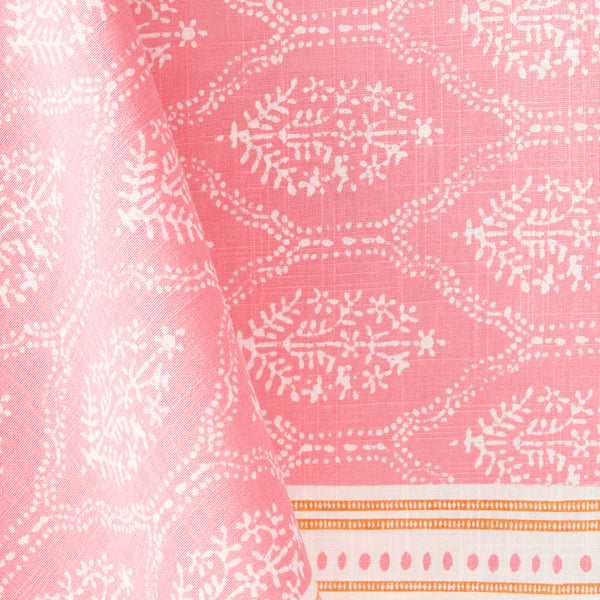 Pink jaali printed fabric close-up with white motif and orange striped edge