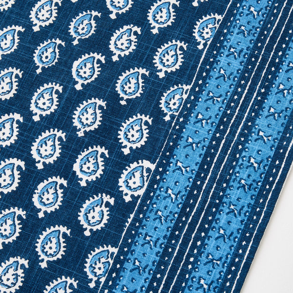 Blue printed runner rug with repeating gear medallion motifs and striped border