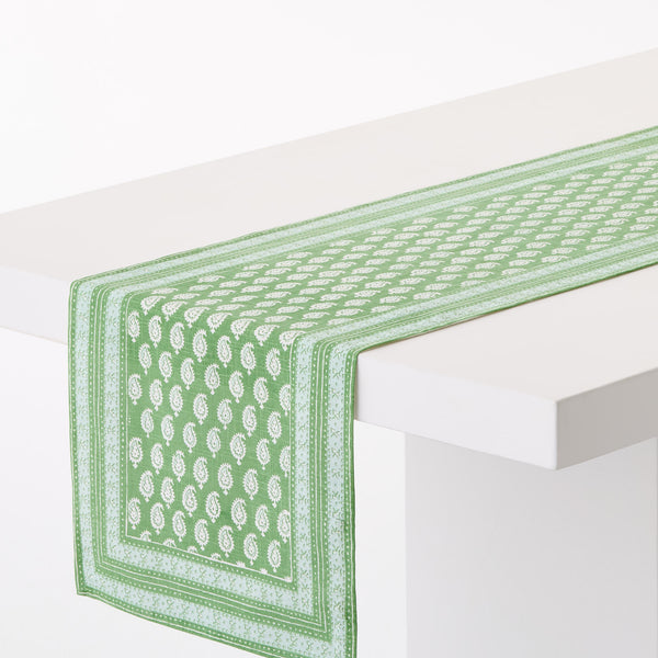 Green printed table runner with white border and corner