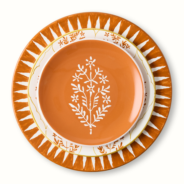 Orange appetizer plate with white floral tree motif, gold leaf rim accents and patterned edge