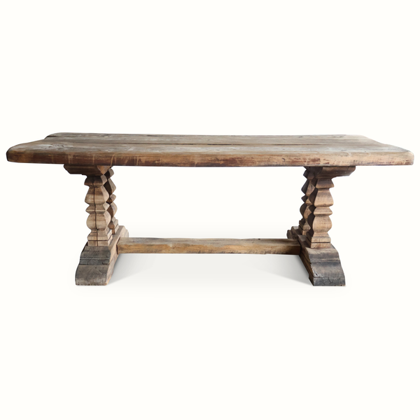 Weathered wood farm table with chunky turned legs and wide rectangular tabletop