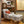 Armchair with light upholstery and blue pattern, in a room setting, rolled arms, caster legs
