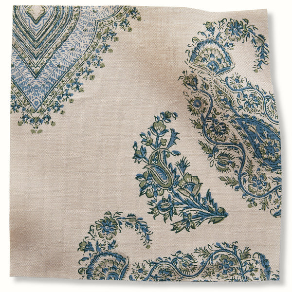 Blue and green floral patterned pillow fabric swatch, neutral background