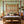 4-poster bed with dark wood posts and woven straw headboard, with patterned bedspread and pillows
