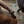Detail of carved wooden arm and dark leather-look armchair upholstery with decorative trim