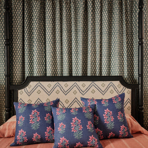 Pink Indian bedcover with white diamond border and dark-blue floral throw pillows