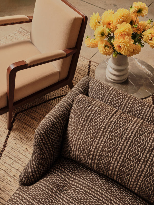 Upholstered armchair with beige seat and back, dark wood arms and legs