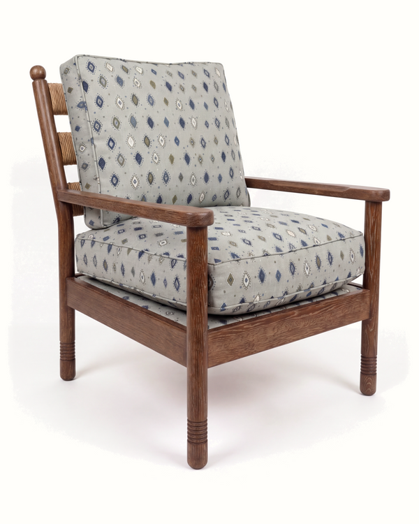 Wood lounge chair with blue diamond-pattern upholstered cushion and tall back panel